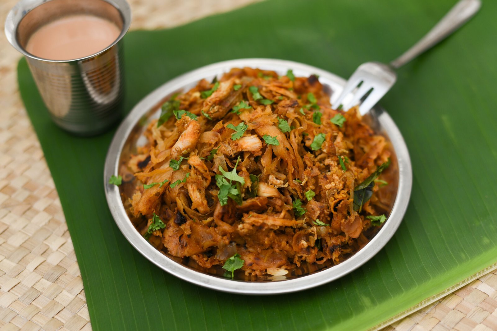 Chicken Kothu Parotta a popular South Indian street food in Kerala made with shredded Porotta, a Indian layered bread and meat. Can be served as snack, lunch, dinner or as a main course dish