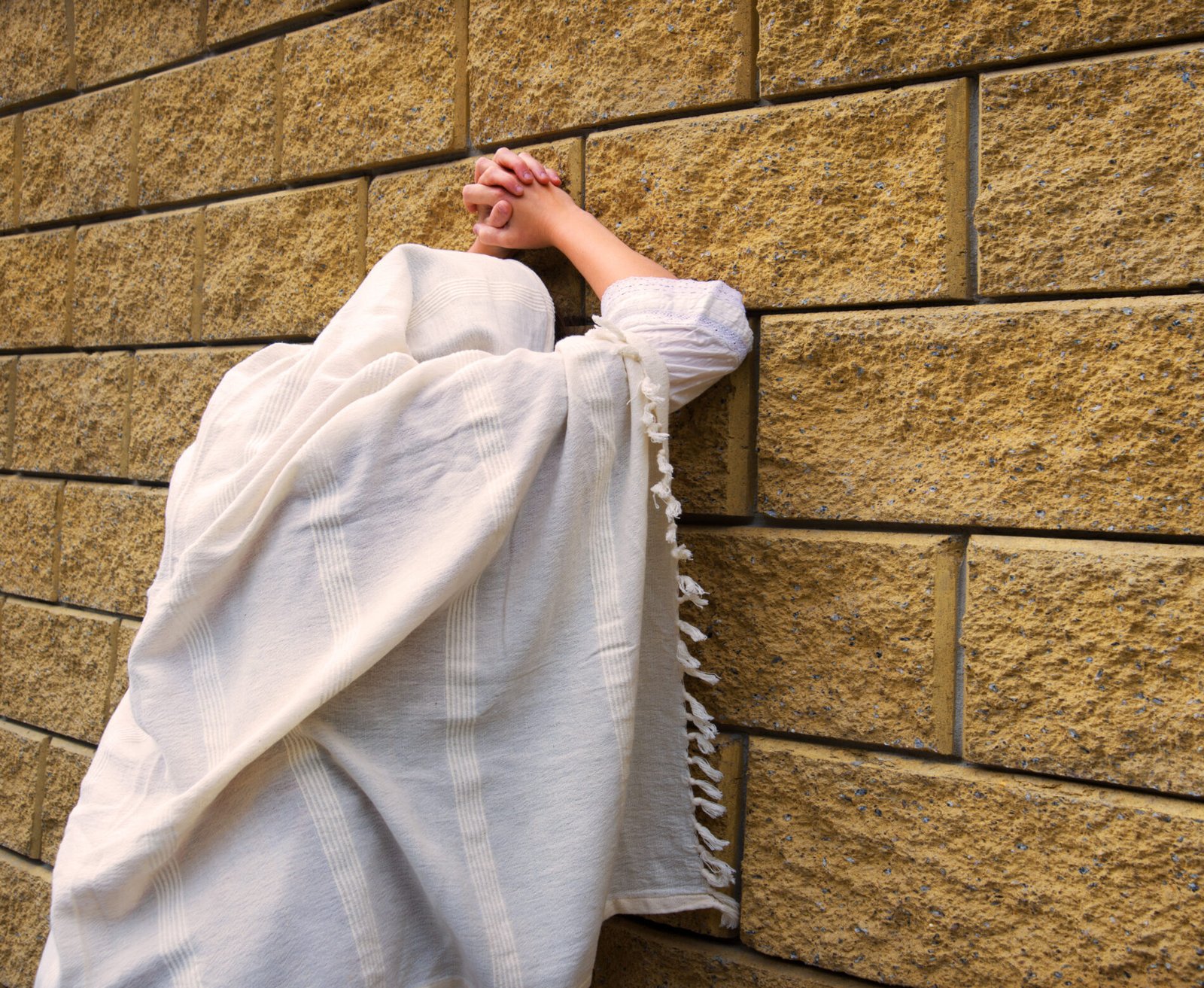 Young woman pray at the wall
